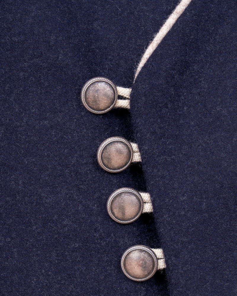Silberne Metallknöpfe auf blauen Stoff
